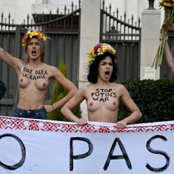 Activistas del grupo feminista Femen sostienen una pancarta en la que se lee "No pasarán" mientras protestan contra la invasión rusa de Ucrania, frente a la embajada rusa en Madrid. | Foto:GABRIEL BOUYS / AFP