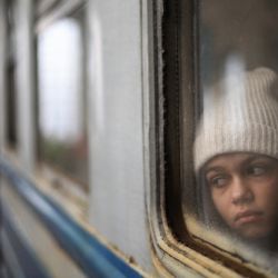 Una niña mira por una ventana mientras espera dentro de un tren que lleva a los refugiados a Polonia en la estación de tren de Lviv, Ucrania occidental. | Foto:DANIEL LEAL / AFP