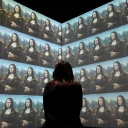 Un visitante observa una pantalla gigante que muestra el retrato de la Mona Lisa de Leonardo Da Vinci antes de la inauguración de la exposición titulada "La Joconde, una exposición inmersiva" en el Palacio de la Bolsa de Marsella, al sur de Francia. | Foto:Nicolas Tucat / AFP