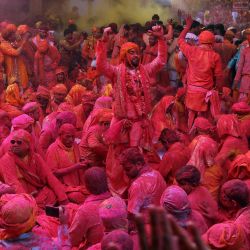 Devotos hindúes embadurnados de colores participan en una reunión tradicional durante las celebraciones de Laddu Holi, el festival primaveral de los colores, en un templo del pueblo de Barsana, en el estado indio de Uttar Pradesh. | Foto:AFP