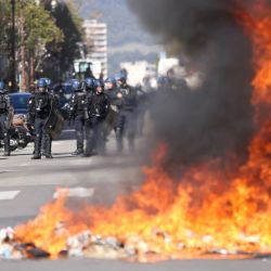 Gendarmes franceses se sitúan detrás de una hoguera de basura ardiendo durante una manifestación de estudiantes de secundaria frente a la prefectura de Corse-du-Sud, Francia. | Foto:PASCAL POCHARD-CASABIANCA / AFP