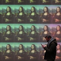 Un visitante pasa por delante de una pantalla gigante que muestra el retrato de Mona Lisa de Leonardo Da Vinci antes de la inauguración de la exposición titulada "La Joconde, una exposición inmersiva" en el Palacio de la Bolsa de Marsella, en el sur de Francia. | Foto:Nicolas Tucat / AFP