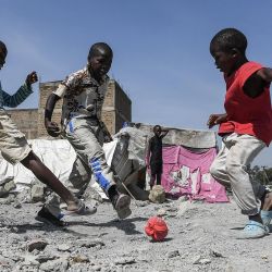 Unos niños juegan al fútbol en una losa de hormigón en los asentamientos informales de Mukuru Kwa Njenga, donde se han demolido estructuras en noviembre de 2021 para allanar el camino a la construcción de la autopista de Nairobi, Kenia. | Foto:Simon Maina / AFP
