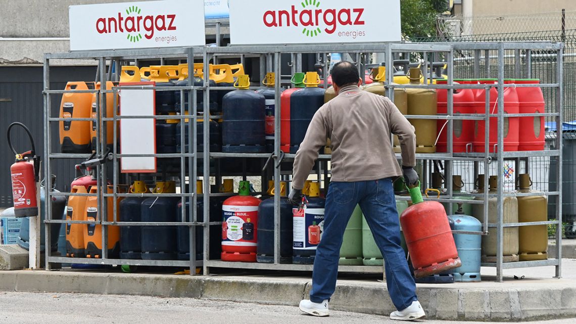 A person picks up a bottle of gas at a gas station in Carnon, southern France, on March 9, 2022. German Economy Minister Robert Habeck on March 9 issued an "urgent appeal" to OPEC oil producers to ramp up output following a spike in prices and supply fears due to the Ukraine crisis.