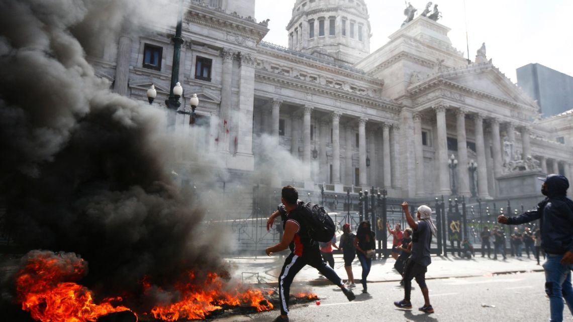 A demonstrator hurls stones to the Congress during a protest against the agreement between Argentina's government and the International Monetary Fund in Buenos Aires on March 10, 2022. 