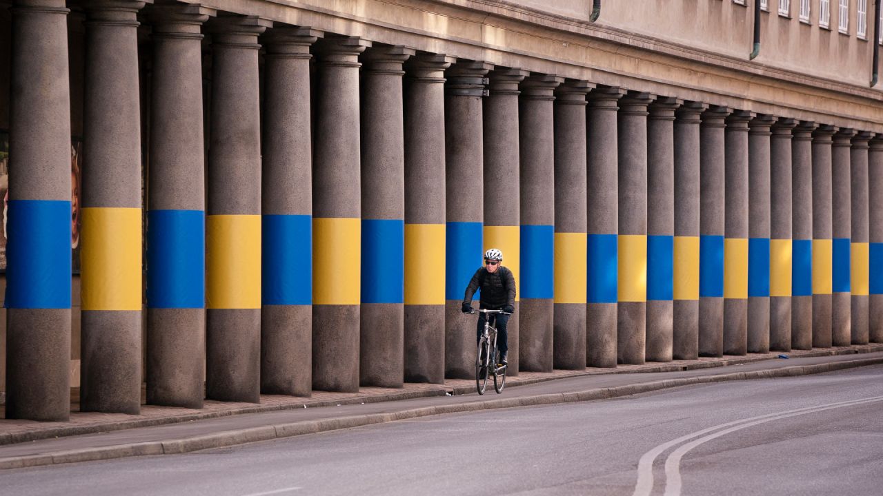 Un ciclista pasa por delante de las columnatas del Museo Nacional decoradas con los colores ucranianos amarillo y azul en apoyo a Ucrania, en Copenhague, Dinamarca. | Foto:Liselotte Sabroe / Ritzau Scanpix / AFP