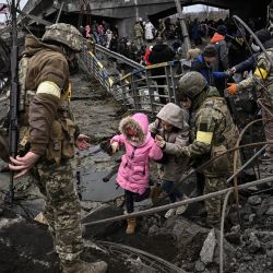 Un grupo de personas cruza un puente destruido mientras evacua la ciudad de Irpin, al noroeste de Kiev, durante un intenso bombardeo de Rusia sobre Ucrania. | Foto:ARIS MESSINIS / AFP