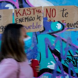 Una mujer pasa junto a los carteles contra el candidato presidencial chileno José Antonio Kast, del partido Republicano, en Santiago, antes de la segunda vuelta de las elecciones presidenciales. | Foto:MARTIN BERNETTI / AFP