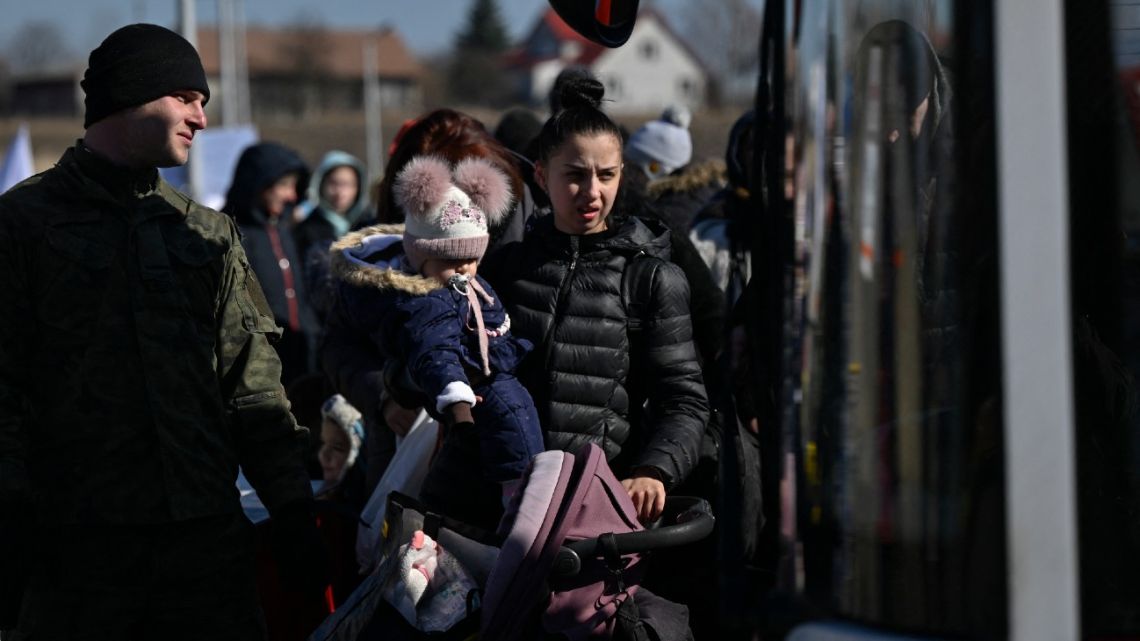 People wait for transportation after crossing the Ukrainian border into Poland, in Medyka, eastern Poland, on March 11, 2022. 