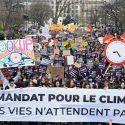 Manifestantes sostienen pancartas durante una marcha "Mira hacia arriba", para pedir a los candidatos presidenciales que tengan en cuenta la emergencia climática, que según los manifestantes está muy ausente de la campaña electoral, menos de dos semanas después de una advertencia de los expertos en clima de la ONU y a un mes de las elecciones presidenciales, en París. | Foto:ALAIN JOCARD / AFP