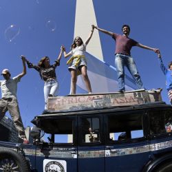 La familia argentina Zapp saluda encima de su coche, un Graham-Paige de 1928, en la plaza de la República de Buenos Aires, tras finalizar un viaje de 22 años alrededor del mundo que comenzó el 23 de enero de 2000. | Foto:JUAN MABROMATA / AFP