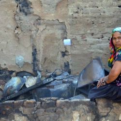 Una mujer se sienta afuera de una cabaña residencial quemada luego de que se registrara un gran incendio, cerca de la aldea de Gokalpur, en el noreste de Delhi, India. | Foto:Xinhua/Str