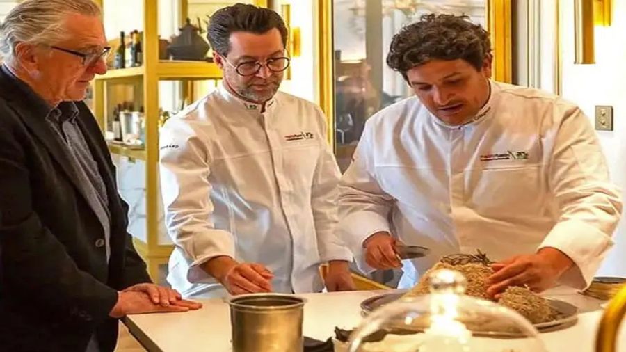 Robert De Niro mira cómo el chef argentino Mauro Colagreco  prepara uno de sus postres, con dulce de leche.