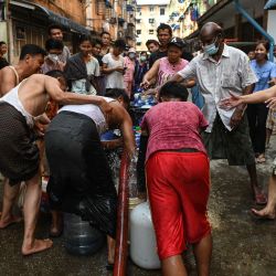 La gente llena contenedores con agua en Yangon, mientras miles de personas se enfrentan a la escasez de agua debido a los cortes de energía en la ciudad. | Foto:AFP