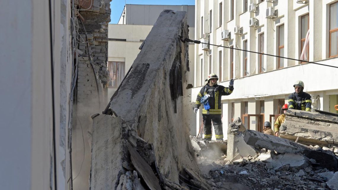 Rescue workers clear the rubble of a building of the Kharkiv Regional Institute of Public Administration damaged by shelling in Kharkiv on March 18, 2022, amid the ongoing Russia's invasion of Ukraine. 