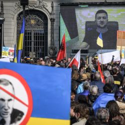 El presidente ucraniano, Volodymyr Zelensky, aparece en una pantalla gigante después de emitir un mensaje de voz en directo durante una manifestación contra la invasión rusa de Ucrania frente a la Casa del Parlamento suizo en Berna. | Foto:FABRICE COFFRINI / AFP