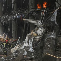 Los bomberos llevan un cargador mientras se abren paso entre los escombros tras los bombardeos rusos que destruyeron el centro comercial Retroville en Kiev. - Al menos seis personas murieron en el bombardeo nocturno de un centro comercial en la capital ucraniana, Kiev, según un periodista de la AFP, mientras los rescatistas rastrean los restos en busca de otras víctimas. | Foto:ARIS MESSINIS / AFP