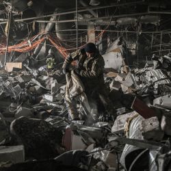 Militares ucranianos buscan entre los escombros del centro comercial Retroville tras un ataque ruso en el noroeste de Kiev. | Foto:ARIS MESSINIS / AFP