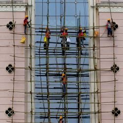 Obreros montan un andamio frente a la fachada de un edificio hospitalario en Mumbai, India. | Foto:INDRANIL MUKHERJEE / AFP