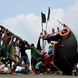 Los pescadores intentan levantar un barco trenzado después de la pesca desde la bahía de Bengala en Teknaf. | Foto:AFP