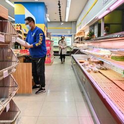 Los compradores hurgan en los estantes vacíos de un supermercado antes del cierre como medida contra el coronavirus Covid-19 en Shanghái.  | Foto:AFP