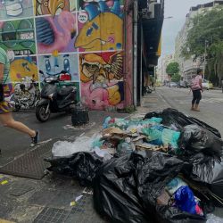 Una mujer pasa junto a la basura en una calle del barrio de Botafogo durante el primer día de huelga de la Empresa Municipal de Limpieza Urbana de Río (COMLURB), en demanda de un aumento de salarios, en Río de Janeiro, Brasil. Mauro  | Foto:AFP