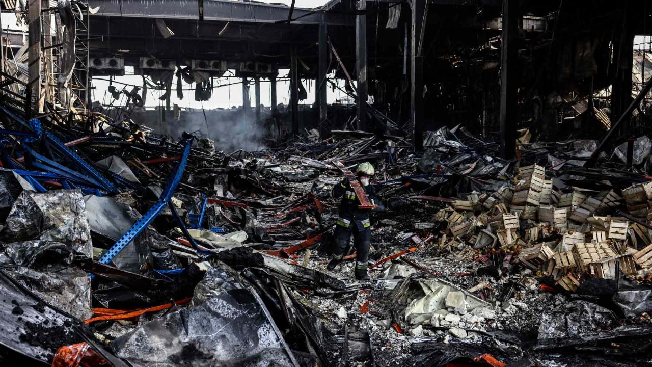 Un rescatista limpia los escombros de un almacén que contiene más de 50.000 toneladas de alimentos congelados en la ciudad de Brovary, al norte de la capital ucraniana de Kiev, después de ser destruido por un bombardeo ruso. | Foto:AFP