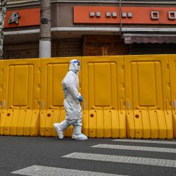  Un trabajador con equipo de protección camina junto a las barreras que separan de la calle un barrio cerrado como medida contra el coronavirus Covid-19 en el distrito de Jing'an, en Shanghái. Hector RETAMAL / AFP | Foto:AFP