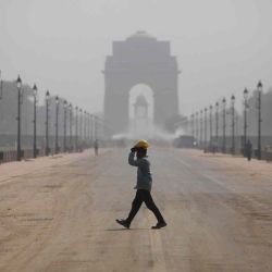 Un trabajador de la construcción cruza el Rajpath en construcción, con la Puerta Inda al fondo, en Nueva Delhi. AFP | Foto:AFP