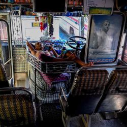 Un conductor de autobús duerme la siesta dentro de un autobús mientras espera el diésel en Colombo. AFP | Foto:AFP