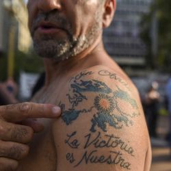 En esta foto de archivo tomada el 3 de enero de 2017, un veterano de la Guerra de las Malvinas (Falklands) de 1982 entre el Reino Unido y Argentina muestra su tatuaje de las islas mientras se manifiesta en la Plaza de Mayo en Buenos Aires el 3 de enero de 2017. , durante el 184 aniversario de la ocupación británica de las islas. - Cuarenta años después de la guerra de las Malvinas/Falklands, Argentina continúa reclamando la soberanía sobre las islas, que la entonces junta militar del país invadió el 2 de abril de 1982. Más de 900 personas murieron, incluidos 655 argentinos, 255 soldados británicos y tres isleños, antes de que Argentina Las fuerzas se rindieron el 14 de junio de 1982. Argentina volvió a la democracia en 1983. (Foto de Eitan ABRAMOVICH / AFP) | Foto:AFP