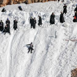 Judíos ultraortodoxos juegan en la nieve en la estación de esquí de Hermón, en los estratégicos Altos del Golán anexionados por Israel. | Foto:JALAA MAREY / AFP