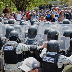 Miembros de la Guardia Nacional impiden el paso a los migrantes que participan en una caravana que se dirige a la Ciudad de México, en una carretera de Tapachula, estado de Chiapas, México. | Foto:DAMIAN SANCHEZ / AFP