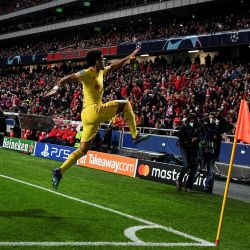 El centrocampista colombiano del Liverpool Luis Díaz celebra tras marcar el tercer gol de su equipo durante el partido de fútbol de ida de los cuartos de final de la UEFA Champions League entre el SL Benfica y el Liverpool FC en el estadio de la Luz en Lisboa. | Foto:PATRICIA DE MELO MOREIRA / AFP