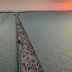 El sol se eleva por encima de la autopista de los Cayos de Florida mientras un grupo de 1.500 corredores compite en la carrera Seven Mile Bridge Run, cerca de Marathon, Florida. | Foto:Andy Newman / Florida Keys News Bureau / AFP