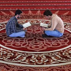 Hombres palestinos leen el Corán en la mezquita de al-hassina durante el mes sagrado musulmán de ayuno del Ramadán en la ciudad de Gaza. | Foto:MOHAMMED ABED / AFP