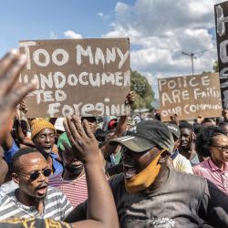 Los residentes sostienen pancartas mientras protestan contra el aumento de la delincuencia en la zona en Diepsloot, Sudáfrica. | Foto:GUILLEM SARTORIO / AFP