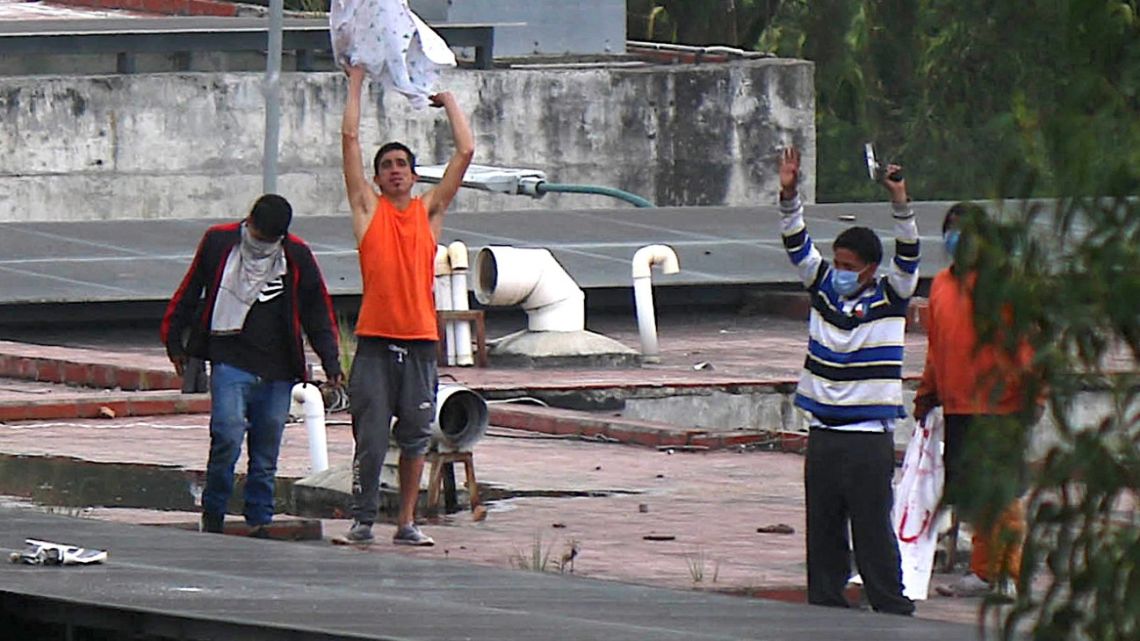 In this photo taken on April 3, 2022, inmates are seen on the roof of the CRS Turi prison after a riot in Cuenca, Ecuador.