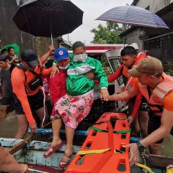 Esta fotografía muestra a personal de la guardia costera y de la policía evacuando a un residente de una zona inundada en la ciudad de Abuyog, provincia de Leyte, sur de Filipinas, tras las fuertes lluvias provocadas por la tormenta tropical Agaton. | Foto:Guardia Costera de Filipinas (PCG) / AFP