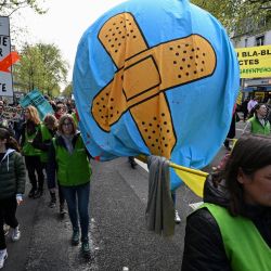 Manifestantes llevan un globo con tiritas durante una marcha "Mira hacia arriba", para pedir a los candidatos presidenciales que tengan en cuenta la emergencia climática, que según los manifestantes está muy ausente en la campaña, en París. | Foto:EMMANUEL DUNAND / AFP