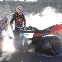 Una persona apaga el fuego mientras el piloto holandés de Red Bull, Max Verstappen, mira su coche durante el Gran Premio de Australia de Fórmula 1 de 2022 en el circuito de Albert Park en Melbourne. | Foto:William West / AFP