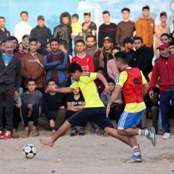 Jóvenes palestinos juegan al fútbol en un campo de refugiados de Rafah, en el sur de la Franja de Gaza, antes de romper el ayuno durante el mes sagrado musulmán del Ramadán. | Foto:SAID KHATIB / AFP