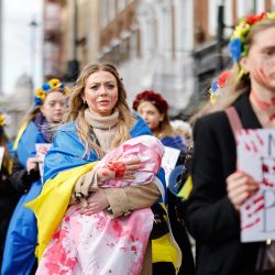 La gente sostiene pancartas y bebés falsos salpicados de sangre en una protesta de apoyo a Ucrania en Whitehall, en el centro de Londres. | Foto:Tolga Akmen / AFP