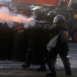 La policía dispara gas lacrimógeno hacia los manifestantes durante una manifestación contra las medidas para ampliar el mandato presidencial en Makassar, Indonesia. | Foto:Andri Saputra / AFP