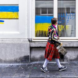 Una persona con un tambor pasa junto al consulado ruso recién pintado con los colores de la bandera ucraniana, en Maastricht. | Foto:Marcel Van Hoorn / ANP / AFP