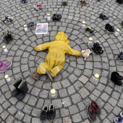 Velas, ropa y zapatos de niños se ven durante una manifestación organizada por la Asociación Ucraniana en Finlandia, para honrar la memoria de los niños asesinados en Mariupol, Ucrania, en Helsinki. | Foto:Jussi Nukari / Lehtikuva / AFP