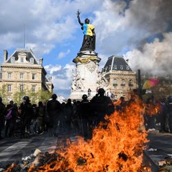 Agentes de policía detrás de una hoguera de basura ardiendo durante una marcha "Mira hacia arriba", para pedir a los candidatos presidenciales que tengan en cuenta la emergencia climática, que según los manifestantes está muy ausente en la campaña, en París. | Foto:EMMANUEL DUNAND / AFP