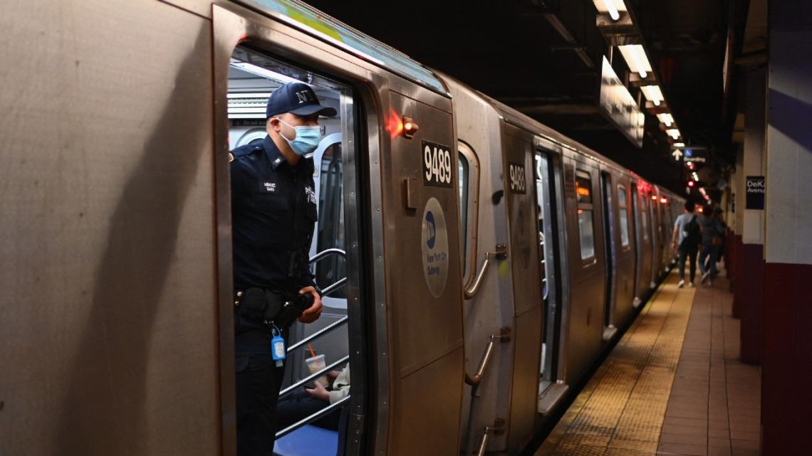 A NYPD officer looks out of a subway car in New York City on April 13, 2022, one day after people were injured during a rush-hour shooting in Brooklyn.