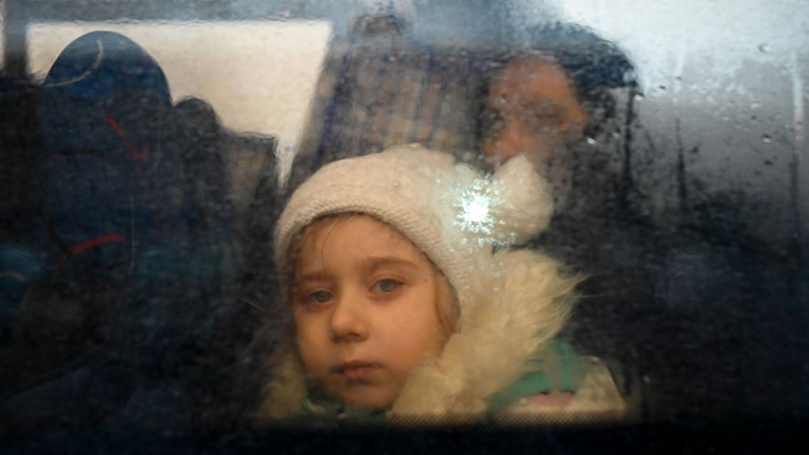 A child fleeing from Ukraine looks on from inside a bus heading to Moldovan capital Chisinau, after crossing the Moldova-Ukraine border checkpoint near the town of Palanca, on March 2, 2022.