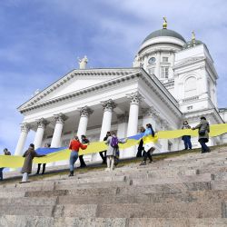 La gente participa en un momento de oración ecuménica por Ucrania y por la paz del mundo en la Plaza del Senado junto a las estrellas de la Catedral de Helsinki en Helsinki, Finlandia. | Foto:Emmi Korhonen / Lehtikuva / AFP